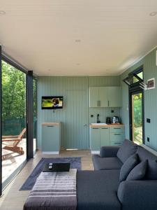 a living room with a couch and a kitchen at Perspective Mirror House in Kocaeli