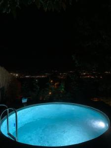 a bath tub at night with a city in the background at Perspective Mirror House in Kocaeli