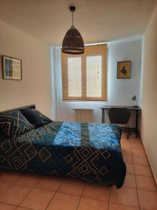 1 dormitorio con cama, mesa y ventana en Grande chambre lumineuse dans un grand t3, en Aix-en-Provence