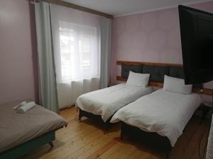 a room with two beds and a tv and a window at Принцеса Анастасия 2 in Chiprovtsi