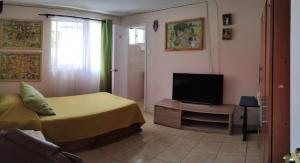 a bedroom with a bed and a flat screen tv at Hostal del Rosario La Serena in La Serena