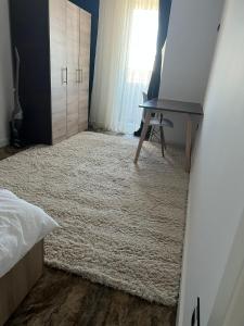 a bedroom with a bed and a desk and a rug at Apartament bloc nou - self check in - free parking in Craiova