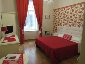 Un pequeño dormitorio con una cama roja y una ventana en Bed and Breakfast Speranzella, en Nápoles