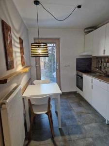 a kitchen with a table and a white table and chair at Studio Bizjak in Vrhnika