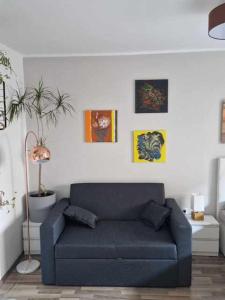 a blue couch in a living room with pictures on the wall at Studio Bizjak in Vrhnika