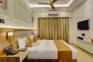 um quarto de hotel com uma cama e uma televisão de ecrã plano em Home2 Studio Apartments em Mumbai