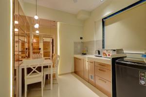 a kitchen with a table and a dining room at Home2 Studio Apartments in Mumbai