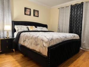 1 cama en un dormitorio con marco de cama negro en Affordable Luxury Home Near NYC & EWR, en Newark