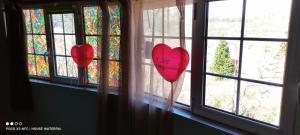 two red hearts are hanging in a window at Guest House Waterfall in Eptalofos