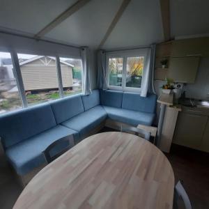 - un salon avec un canapé bleu et une table dans l'établissement Seacottage Blankenberge - Wenduine, au Coq