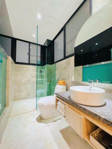 y baño con lavabo y ducha acristalada. en Enjoy Homestay en Anping