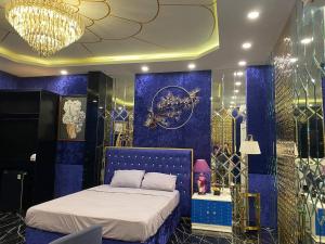 Thôn Dương Xuân HạにあるHOÀNG GIA ATHENA HOTELのベッドルーム1室(青い壁のベッド1台、シャンデリア付)
