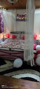 sypialnia z łóżkiem z białymi zasłonami i czerwonymi poduszkami w obiekcie Guest House Waterfall w mieście Eptalofos