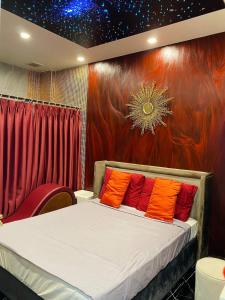 Thôn Dương Xuân HạにあるHOÀNG GIA ATHENA HOTELのベッドルーム1室(オレンジと赤の枕が付いたベッド1台付)