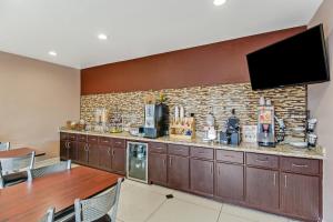 eine Küche mit einer Bar mit einem TV an einer Backsteinwand in der Unterkunft Americas Best Value Inn - FM 529 in Houston