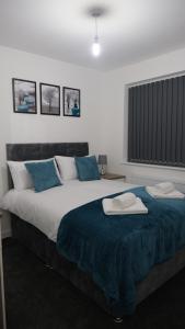 a bedroom with a large bed with two towels on it at EtihCity - 3 Bedroom Semi with Sky n Netflix near Etihad Football Stadium, Tourist attractions, Manchester City Centre Transport Links and Opposite to McDonald's in Manchester