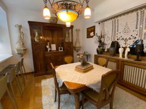 une salle à manger avec une table, des chaises et un lustre dans l'établissement Villa Thalassa domaineleshesperides, à Bitche
