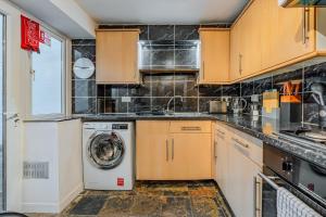 a kitchen with a washer and a washing machine at Chic Victorian Basement Flat in Bristol