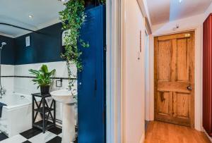 baño con puerta azul y lavamanos en Chic Victorian Basement Flat en Bristol