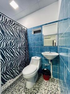 a bathroom with a toilet and a sink at Hotel y Restaurante El Cafetalito in Conchagua