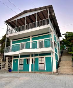 een blauw-wit gebouw met een balkon bij Hotel y Restaurante El Cafetalito in Conchagua
