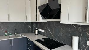 a kitchen with white cabinets and a stove top oven at London Studios and Suites in Harrow +92 photos