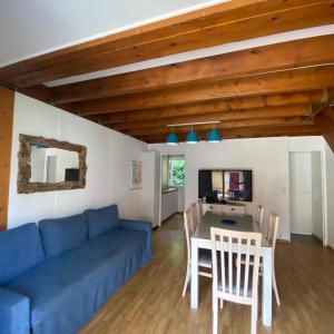 a living room with a blue couch and a table at Villa Soustons Plage / Résidence les villas du lac avec piscine in Soustons