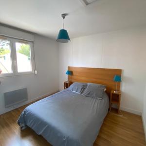 a bedroom with a large bed with a wooden headboard at Villa Soustons Plage / Résidence les villas du lac avec piscine in Soustons +8 photos