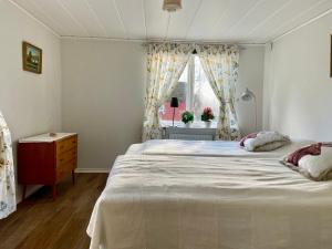 een slaapkamer met een groot bed en een raam bij Holiday home Småland Siggamåla in Husjönäs