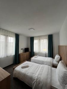 a hotel room with two beds and windows at Hotel Han Jelica in Konjic