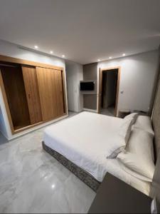 um quarto com uma grande cama branca num quarto em La perla hills 3 chambres em Tânger