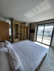 um quarto com uma cama grande e uma janela grande em La perla hills 3 chambres em Tânger
