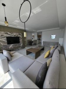uma sala de estar com um sofá grande e uma mesa em La perla hills 3 chambres em Tânger