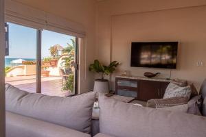 a living room with a couch and a flat screen tv at Espectacular Villa Frente al Mar in Puerto Vallarta