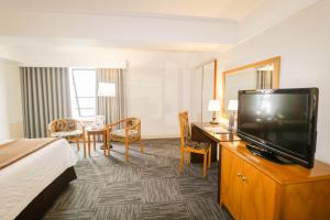 ein Hotelzimmer mit einem Bett und einem Flachbild-TV in der Unterkunft Hotel Miramar in Lima