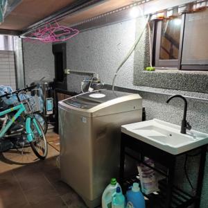 a washing machine and a sink in a room at Huitaro Homestay in Yuli