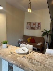 una sala de estar con una mesa con copas de vino. en Apartamento Perto Da Praia 1, en Río de Janeiro