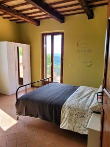 um quarto com uma cama e uma grande janela em Agriturismo Merlino - Natur pur em Pergola