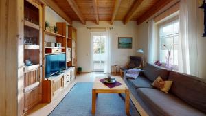 - un salon avec un canapé et une télévision dans l'établissement Ferienhaus Zur Mühle Mitling-Mark, à Westoverledingen