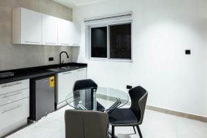 a kitchen with a glass table and two chairs at Luxury 2-Bedroom Apt at Achimota in Taifa