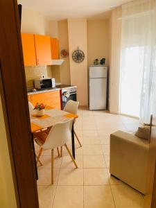 a small kitchen with a table and a refrigerator at Melody Apartament 1 in Golem
