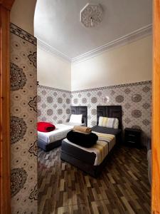 a hotel room with two beds and a couch at Dar Lala Haniya in Rabat