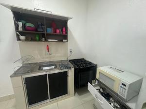 małą kuchnię z kuchenką i kuchenką mikrofalową w obiekcie Casa - Temporada Cuiabá MT w mieście Cuiabá