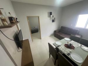 una pequeña sala de estar con mesa y sofá en Casa - Temporada Cuiabá MT en Cuiabá