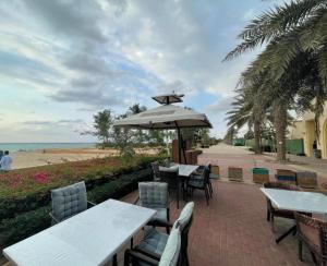 een patio met tafels en stoelen en een parasol bij مسارات النور in King Abdullah Economic City