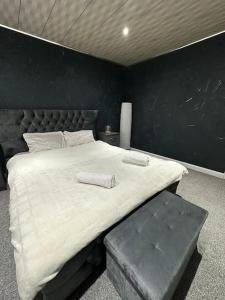 a bedroom with a large bed and a black wall at Charming Heywood retreat house in Heywood