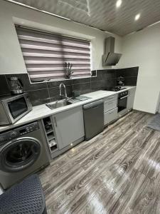 a kitchen with a sink and a washing machine at Charming Heywood retreat house in Heywood