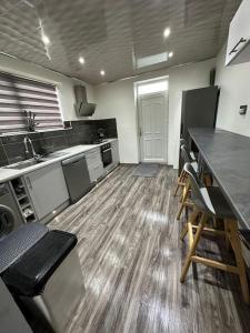 a large kitchen with a counter and chairs in it at Charming Heywood retreat house in Heywood