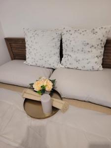 a bed with a candle and flowers on it at Apartament Velana in Reşiţa