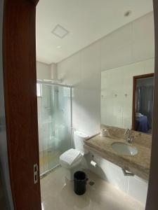 a bathroom with a toilet and a sink and a shower at Flats Grangeiro in Crato